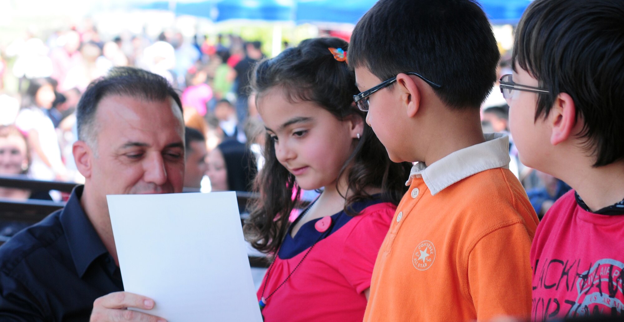 Col. Deniz Kartepe, the commander of the 10th Tanker Command, presents certificates to winners of the Art and Poetry contest at a Children?s Day festival April 17, 2011, at Incirlik Air Base, Turkey. The event was hosted by the Turkish air force 10th Tanker Command and was open to all Incirlik personnel. The event offered an opportunity for camaraderie and partnership-building for all personnel here, and was a chance to celebrate both Turkish children on their national holiday and military children during the Month of the Military Child, officials said.  (U.S. Air Force photo by 1st Lt. Gina McKeen/Released)