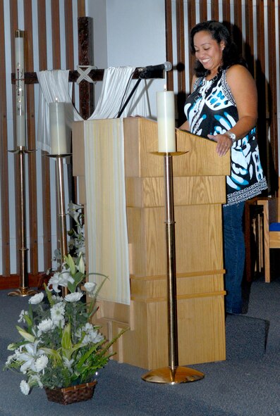 Itzel Delzingaro, assistant Catholic religious education coordinator, shares a reading as part of her duties a volunteer lector at Chapel 1 April 27. Mrs. Delzingaro has been chosen as the Pacific Air Force's nominee to receive the Zachary and Elizabeth Fisher Distinguished Humanitarian Civilian Award, due to her demonstrating exceptional patriotism and humanitarian concern for members of the Armed Forces and their families. (U.S. Air Force photo/ Airman 1st Class Tara A. Williamson)