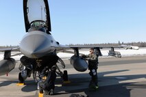 EIELSON AIR FORCE BASE, Alaska – Staff Sgt. Jason Muhle, 8th Aircraft Maintenance Squadron 80th Aircraft Maintenance Unit dedicated crew chief, and Capt. Davis Dugger, 80th Fighter Squadron pilot, perform a pre-flight inspection before Captain Dugger flies a simulated combat sortie April 15 during RED FLAG-Alaska at Eielson Air Force Base. RF-A is a Pacific Air Forces-directed field training exercise for the United States and allied forces to train under simulated air-combat situations. (U.S. Air Force photo/Staff Sgt. Thomas Skinkle)