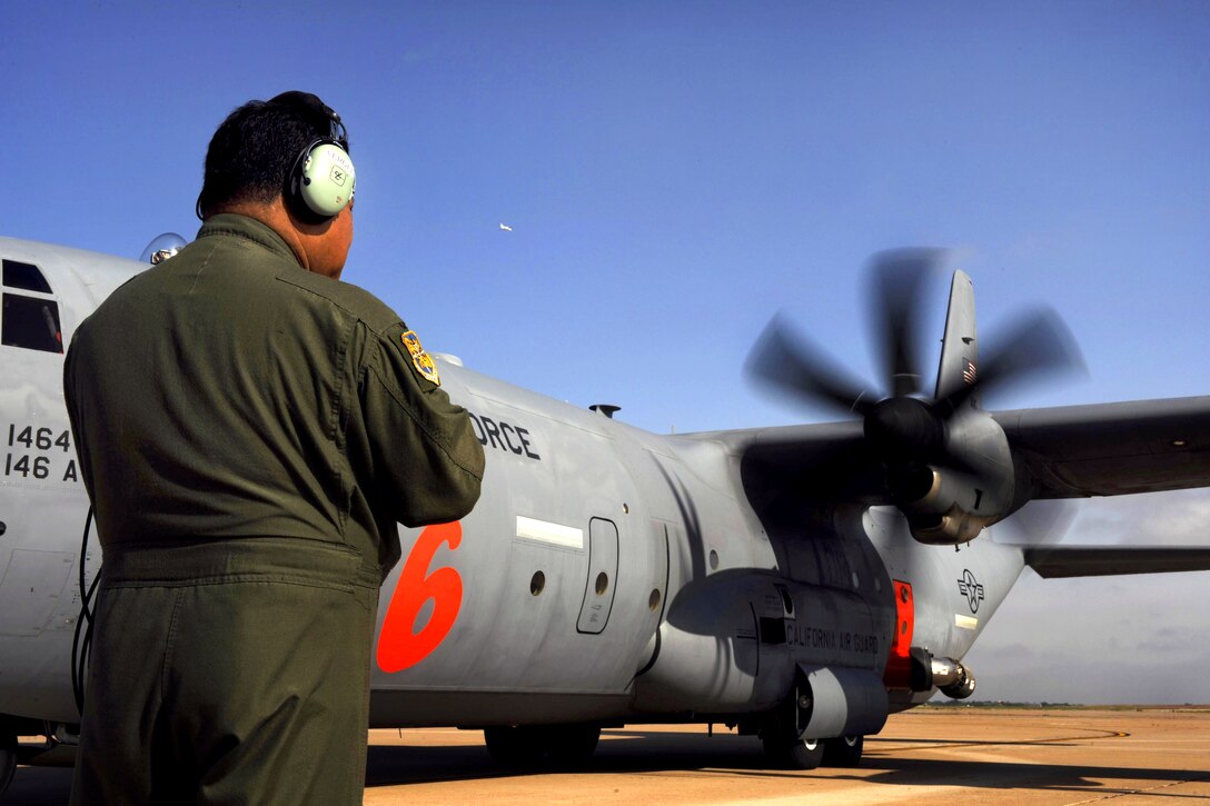 U.S. Air Force Senior Master Sgt. Vergel De Dios checks for engine leaks and other problems as a C-130J Hercules aircraft starts its engines during firefighting operations on Dyess Air Force Base, Texas, April 26, 2011. De Vios is assigned to the 115th Airlift Squadron, California Air National Guard.