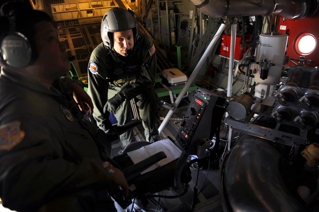 U.S. Air Force Tech. Sgt. Marc Garnsey and Senior Master Sgt. Vergel De Dios fill the Modular Airborne Firefighting System with fire retardant while aboard a C-130J Hercules aircraft 0n Dyess Air Force Base, Texas, April 26, 2011. Garnsey and De Dios are assigned to the 115th Airlift Squadron, California Air National Guard.