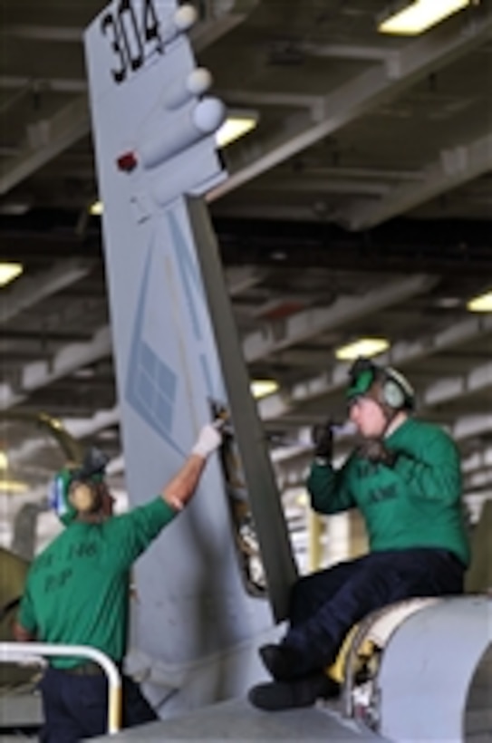 Airman German Alulzo (left) strips sealant out of a rudder as Airman Kells Dean reinstalls a rudder bearing during phase A inspection on an F/A-18C Hornet aircraft aboard the aircraft carrier USS Ronald Reagan (CVN 76) in the Pacific Ocean on April 25, 2011.  