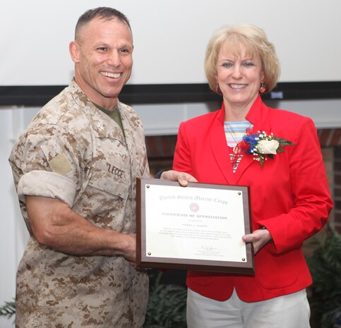 Col. Daniel J. Lecce, commanding officer of Marine Corps Base Camp Lejeune, presents Debbie Martin, supervisory management program analyst, with a certificate of appreciation during her retirement luncheon April 28. Martin retired April 30 after 38 years of civil service.