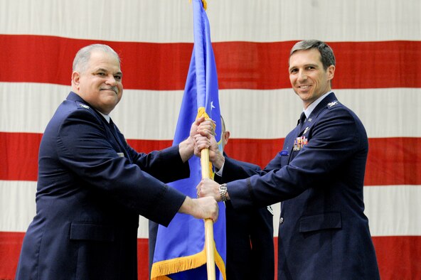 Colonel Mark Clemens, passes the unit guidon to the new Commander, Colonel Bryan Radliff at an assumption of command ceremony at Joint Base Elmendorf-Richardson Apr 15.