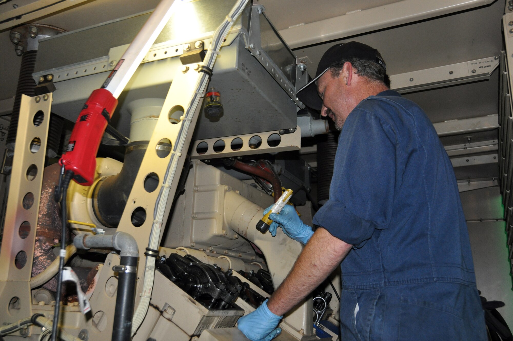 Mike Powers, Civil Engineer Maintenance Inspection Repair Team industrial mechanic, repairs a tactial generator April 27, which will be sent to Japan in support of the mandatory 25 percent energy reduction. Seventeen generators are being sent to Misawa and Yokota air bases in Japan. (U.S. Air Force photo/Airman 1st Class Michael Battles)