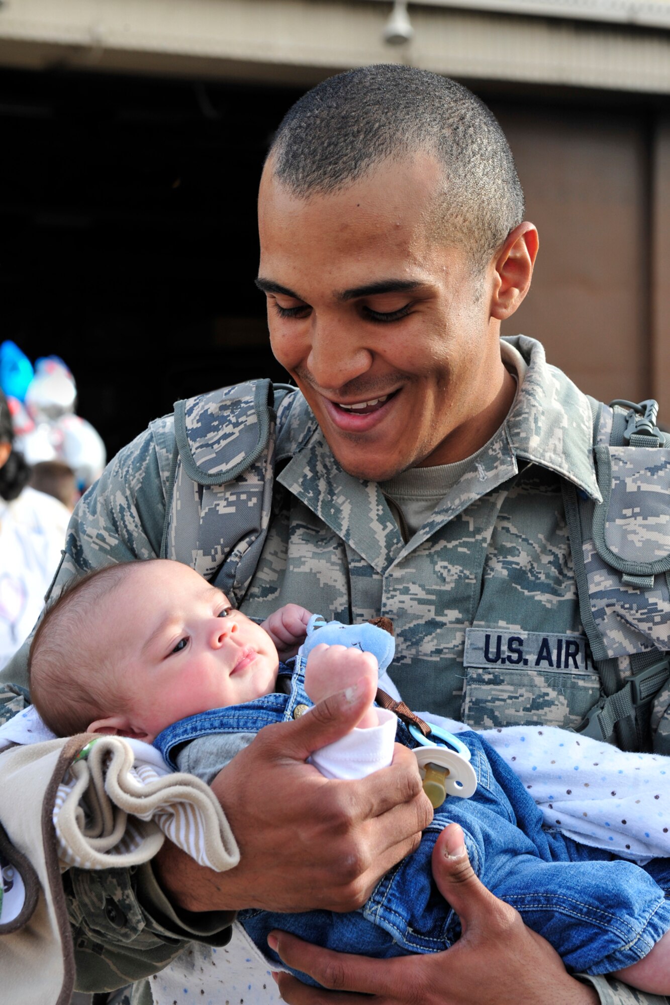 Senior Airman Jordan Orr holds his baby boy for the first time upon his arrival at Hill on April 23 from a nearly seven month deployment at Bagram Airfield, Afghanistan. (U.S. Air Force photo by Kim Cook)