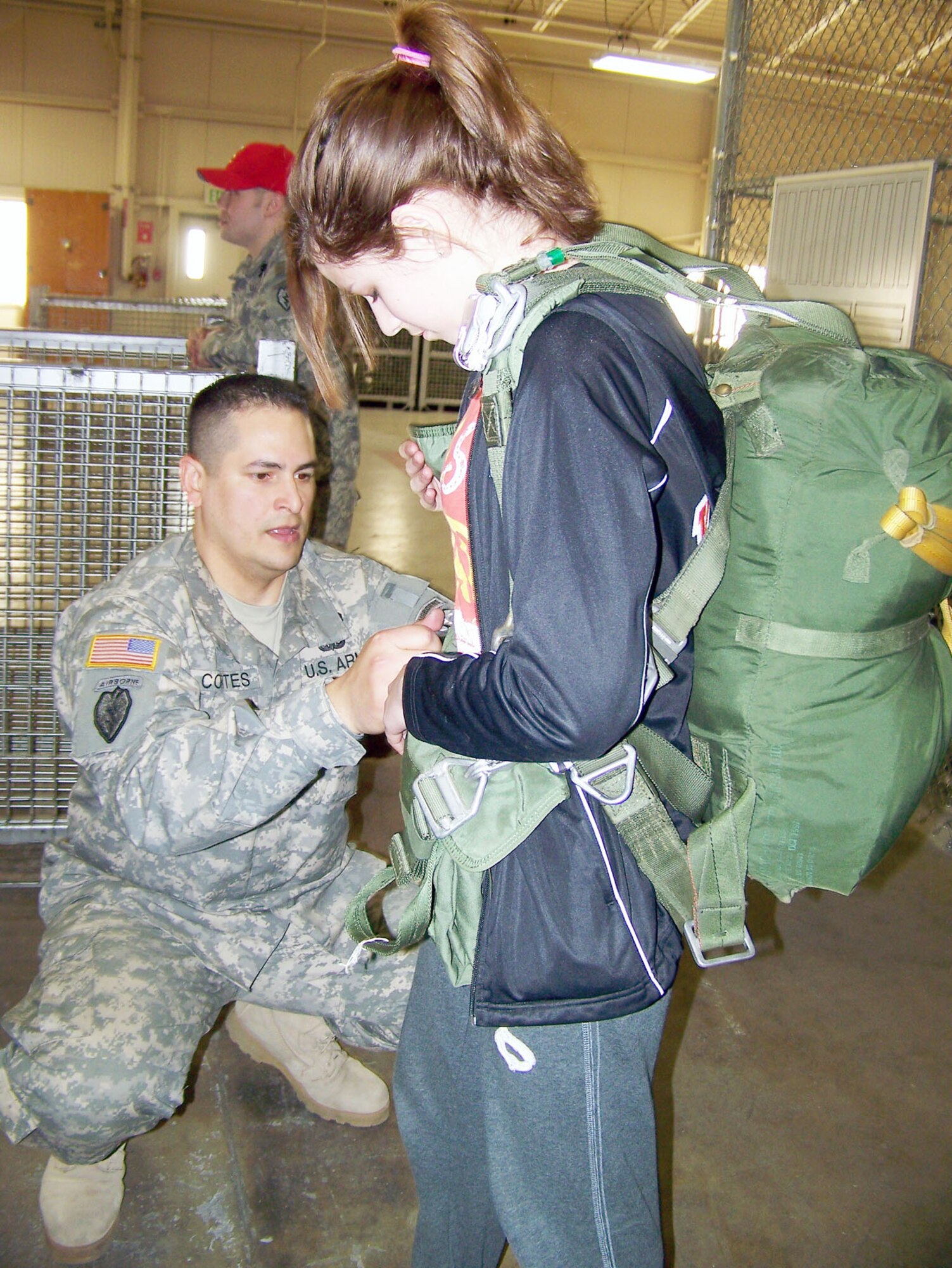 First Sgt. Carlos Cortes, 1st sergeant of Headquarters and Headquarters Company, 725th Brigade Support Battalion, shows a student from Yakutat Junior-Senior High School how to conduct a jumpmaster pre-inspection during a military experience day hosted by HHC, 4th Brigade Combat Team (Airborne), 25th Infantry Division. The exchange program brought middle school students from remote Yakutat, Alaska, to Joint Base Elmendorf-Richardson during an urban experience week in Anchorage. 
 (U.S. Army photo\Capt. Chase Spears) 