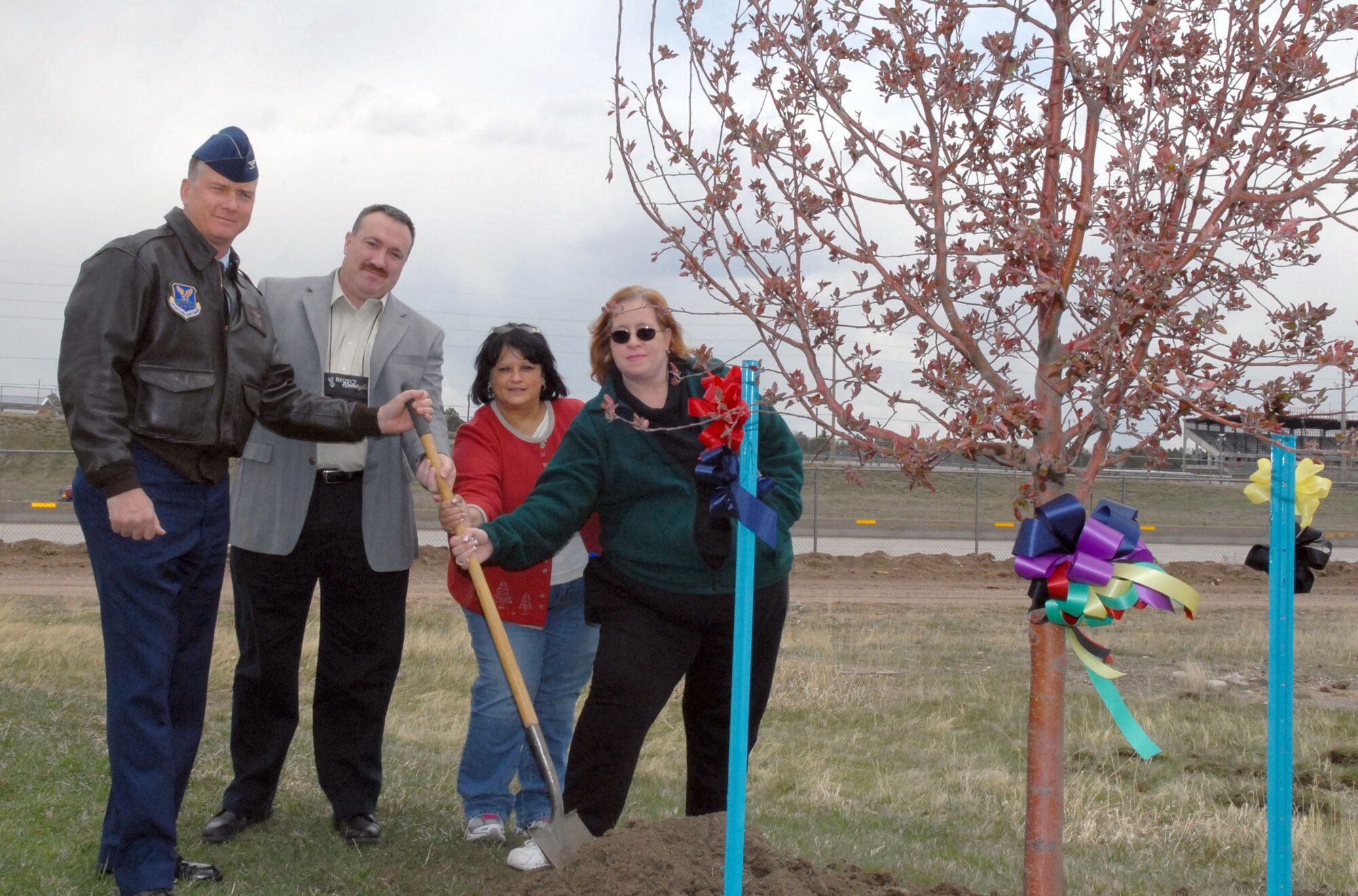 Col. Greg Tims, 90th Missile Wing commander; Marty Peek and Kathy McCoole, Sexual Assault Prevention and Response Program; and Bonnie Scotto, Victim witness coordinator; pose at the dedication of a tree at the 13th hole of the base golf course in commemoration of the second-annual F. E. Warren Air Force Base Crime Victims’ Rights Week, Monday. (U.S. Air Force photo by R.J. Oriez)