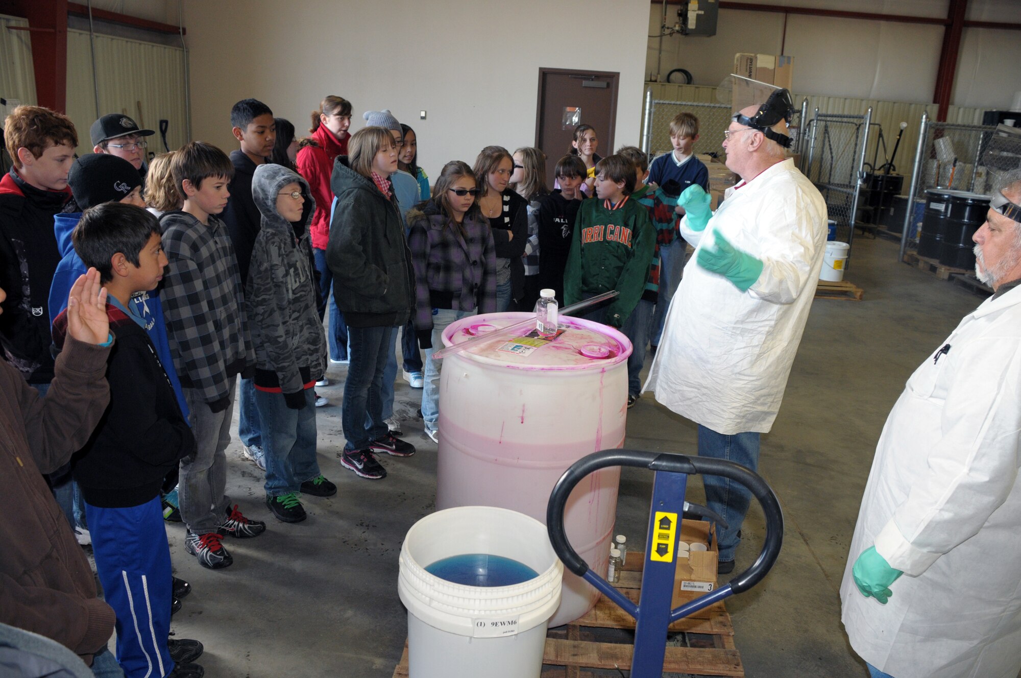 Bill Goings and Joe Trevino, both from 90th Civil Engineer Squadron, explain the process to recycle drums and take samples of unknown fluids to children from Freedom Elementary at Warren’s recycling center during the school’s Earth Day tour of the base’s conservation efforts April 21. (U.S. Air Force photo by Blaze Lipowski)