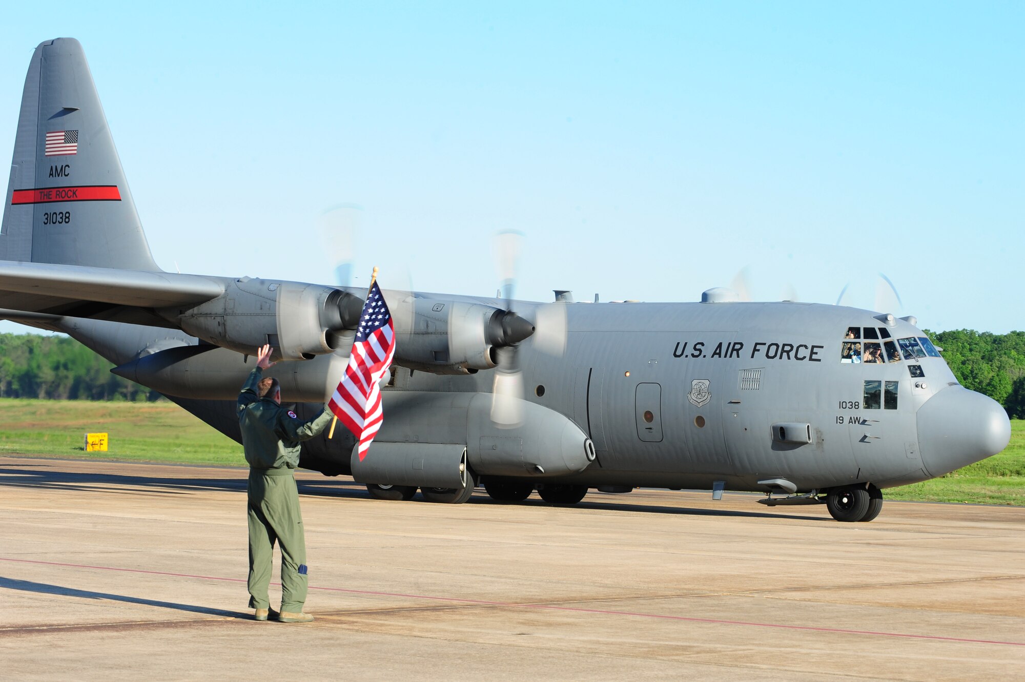 Col. Mike Minihan, 19th Airlift Wing commander, waves the U.S. flag as a C-130H taxi towards a deployment to Southwest Asia on April 28, 2011 at Little Rock Air Force Base, Ark. Airmen and aircraft from the 50th Airlift Squadron “Red Devils” leave for deployment to Southwest Asia. This is the first deployment of Airmen and aircraft from Little Rock Air Force Base following an F-2 tornado that struck the base the evening of April 25 and damaged more than 100 on-base housing units, damaged three C-130 aircraft and blew the roofs off and damaged many buildings in the base's flightline area. (U.S. Air Force photo by Senior Airman Jim Araos)