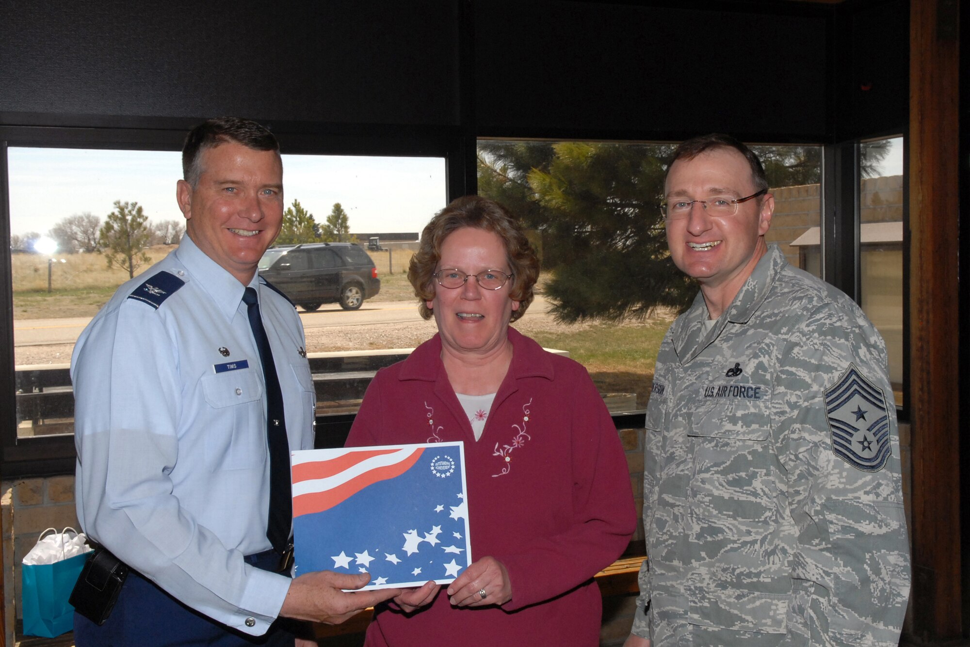 Julane Wood is honored April 20 by Col. Greg Tims, 90th Missile Wing commander, and Chief Master Sgt. Marty Anderson, 90th MW command chief, for her work with the F. E. Warren Air Force Base Tax Assistance Center April 20. Ms. Wood completed 91 returns, more than any other volunteer. Capt. Star Lopez, 90th MW Judge Advocate office, reported the center completed 916 returns this year, earning their clients more than $1.75 million in refunds and saving them $140,800 in preparation fees. (U.S. Air Force photo by R.J. Oriez