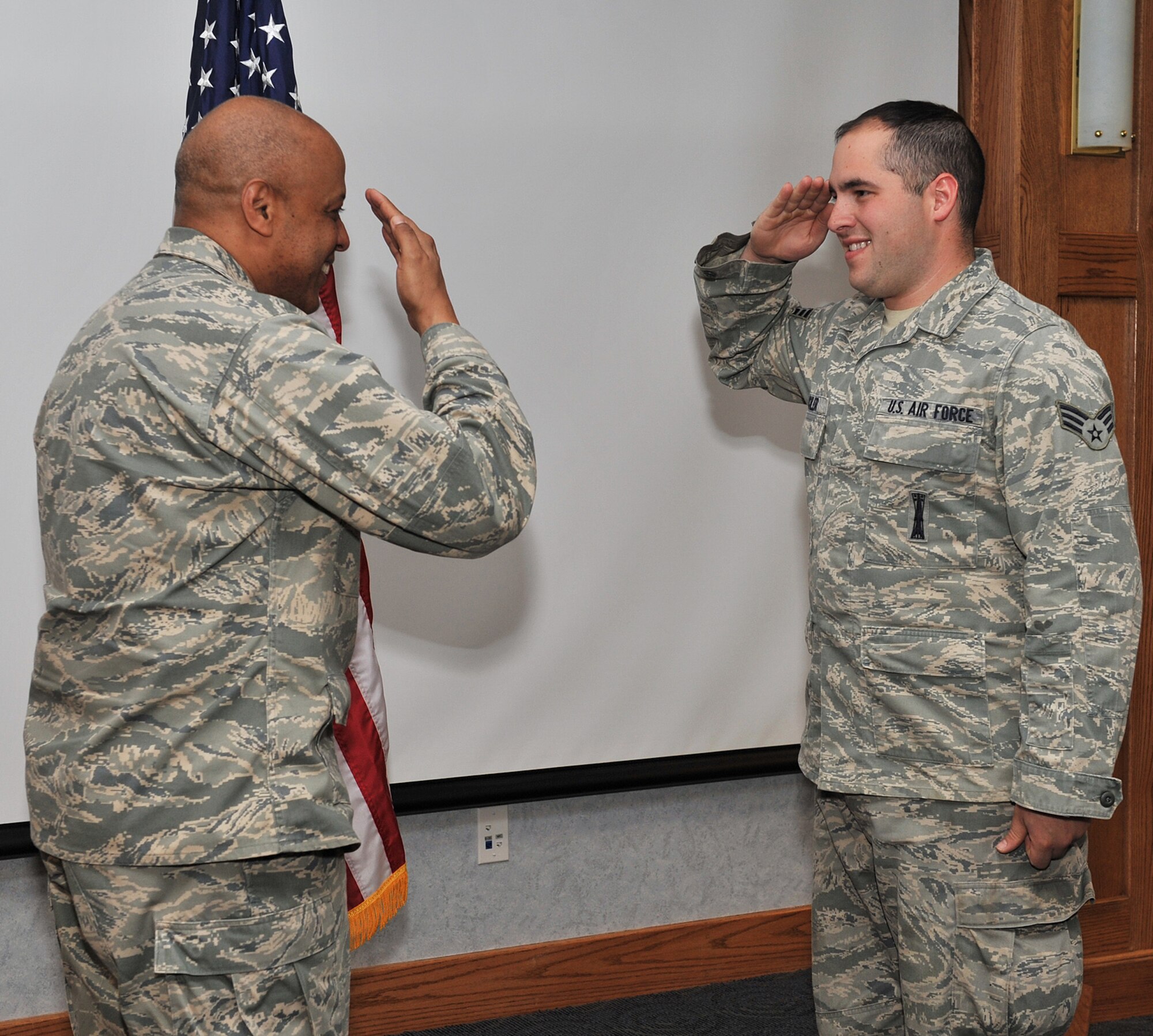 Senior Airman Nicholas Michler renders a salute to Brig. Gen. (Sel) Anthony Cotton April 22 after the 341st Missile Wing commander "coined" the Airman for making his 100th safe trip to the missile complex driving a payload transporter. Airman Michler is a member of the 341st Missile Maintenance Squadron. (U.S. Air Force photo/John Turner)