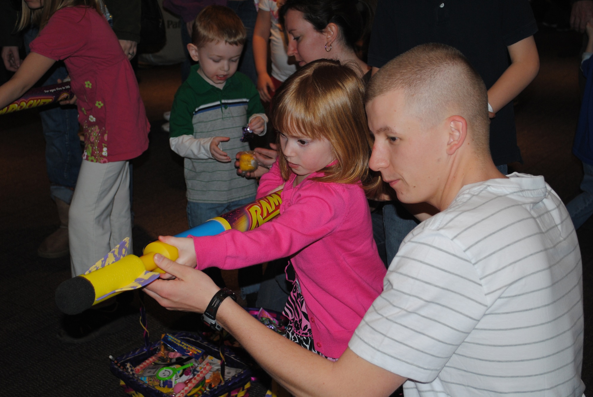 Shae Sweeney, 4, shoots a nerf gun at a target with a little help from volunteer Airman 1st Class Michael Johnston, 341st Force Support Squadron food service apprentice.  Several Airmen from around Malmstrom helped children play games at the Spring Carnival April 23.  (U.S. Air Force photo/Airman Cortney Hansen)
