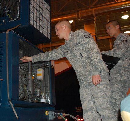 Staff Sgt. Kyle Babbert, Papa 02 Team Chief for the 341st Missile Maintenance Squadron periodic maitenance team, performs some maintenance checks on the alternate power unit of the PMT van while Senior Airman Ray Deleon Guerrero reads from the technical order. The two were part of a five person team performing inspection and inventory duties during van day April 26. (U.S. Air Force photo/Valerie Mullett)