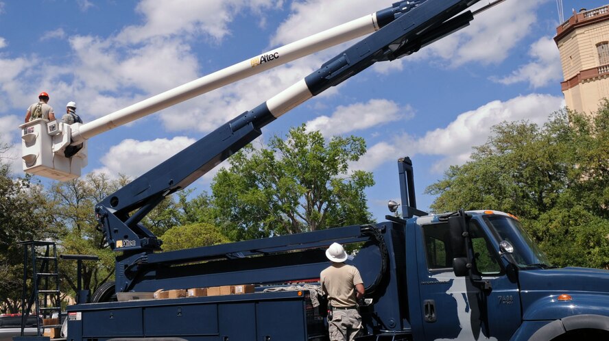 Staff Sgt. Joshua Clanton, 2nd Civil Engineer Squadron electrical systems craftsman, operates the control system on a cherry-picker at the 2nd Bomb Wing Headquarters on Barksdale Air Force Base, La., April 27. The crew repaired the infrastructure in front of the building after relocating more than 100,000 bees and a 30 lb honeycomb. (U.S. Air Force photo/Senior Airman La'Shanette V. Garrett) (RELEASED)