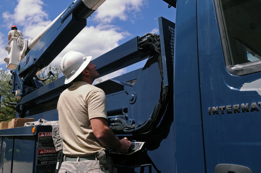 Staff Sgt. Joshua Clanton, 2nd Civil Engineer Squadron electrical systems craftsman, operates the control system on a cherry-picker at the 2nd Bomb Wing Headquarters on Barksdale Air Force Base, La., April 27. The crew repaired the infrastructure in front of the building after relocating more than 100,000 bees and a 30 lb honeycomb. (U.S. Air Force photo/Senior Airman La'Shanette V. Garrett) (RELEASED)
