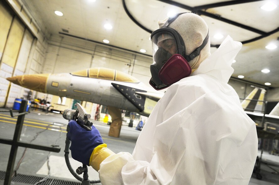 Painter Chris Spivey prepares a spray nozzle before applying primer to an F-15 April 15. U. S. Air Force photo by Sue Sapp