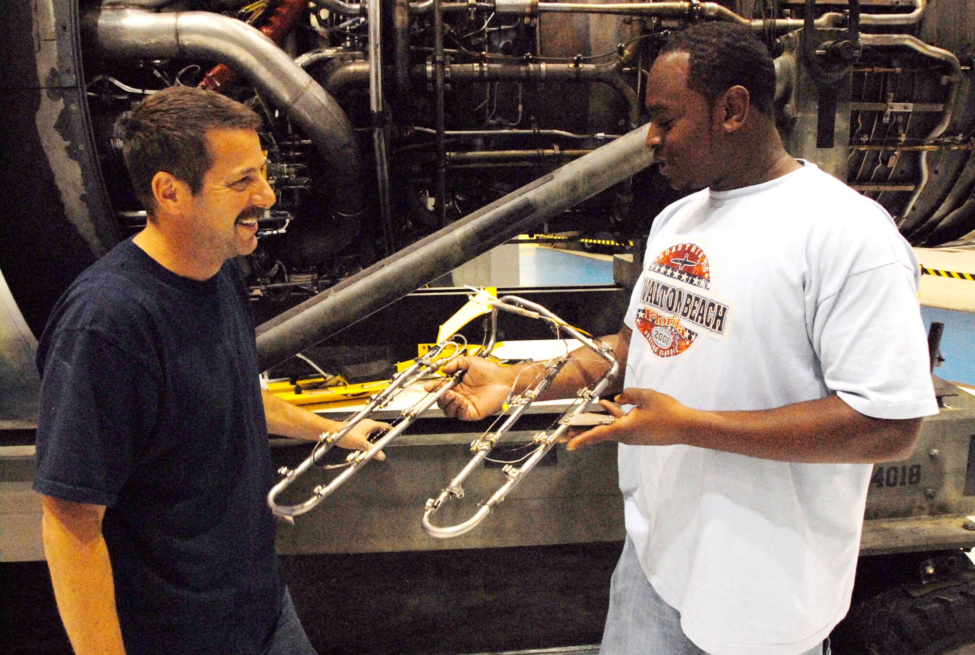 David Murray and Terrance Diggins, C-5 electricians, examine a fire-loop sensor similar to the one replaced. U. S. Air Force photo by Wayne Crenshaw