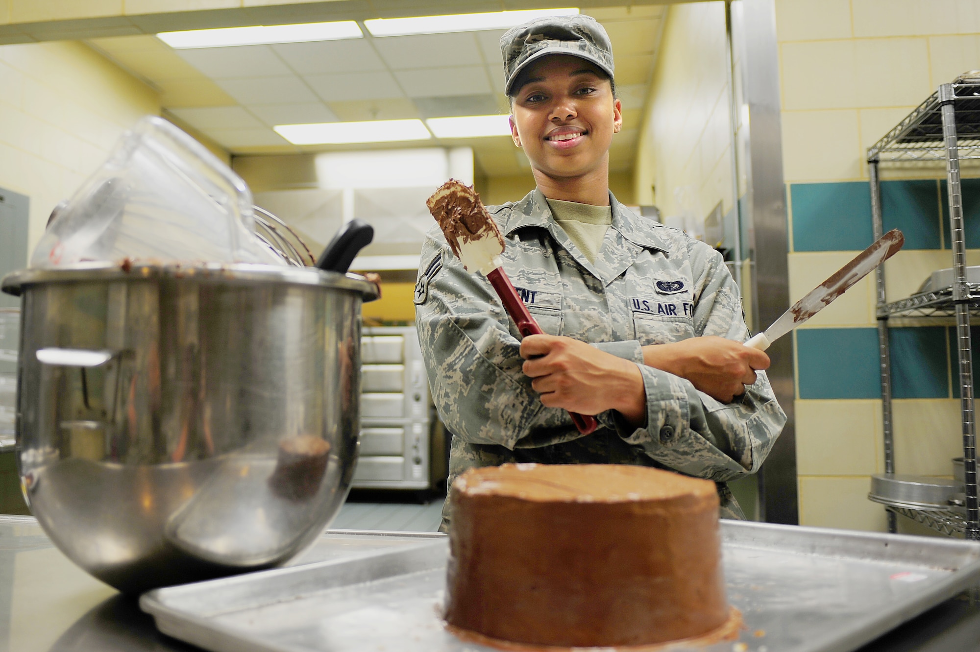 SEYMOUR JOHNSON AIR FORCE BASE, N.C. -- Airman 1st Class Precious Avent poses with her finished cake at the Southern Eagle Dining Facility here, April 28, 2011. Airman Avent was recently awarded an opportunity to attend a culinary class at the Culinary Institute of America at Greystone Campus in St. Helena, Calif. Airman Avent is a 4th Force Support Squadron services journeyman and hails from Henderson. (U.S. Air Force photo/Senior Airman Rae Perry) (RELEASED)