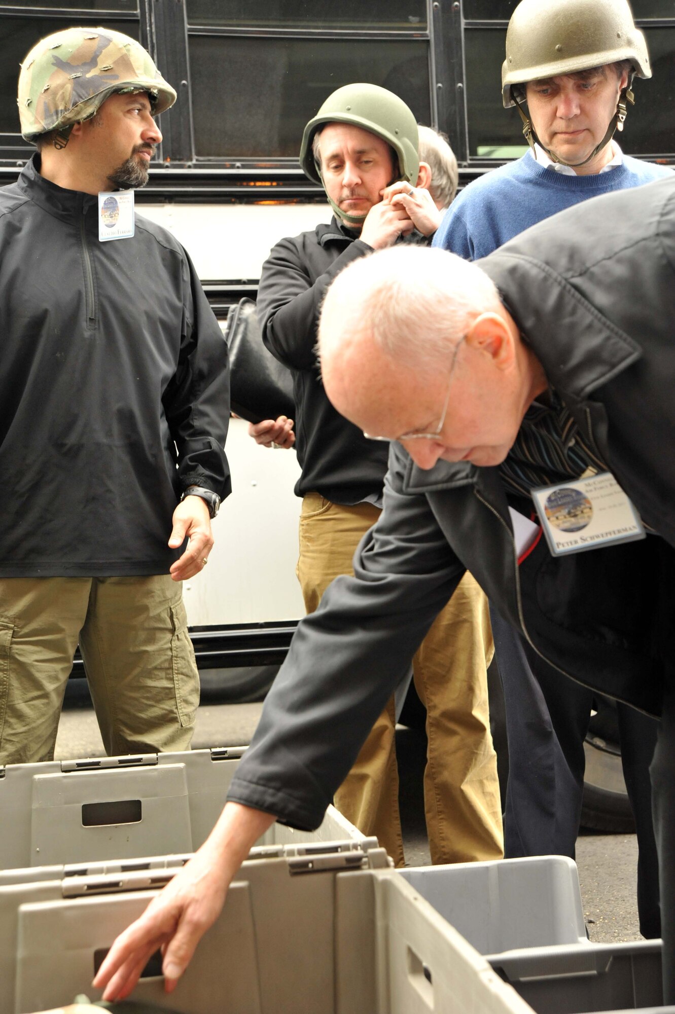 Kansas civic leaders search through a container of protective equipment before riding a Mine Resistant Ambush Protected Vehicle roll-over simulator April 20, 2011, Joint Base Mcguire-Dix-Lakehurst, N.J. More than 20 civic leaders from Wichita, Kan., partipated in McConnell's first civic leader tour in more than five years.  (U.S. Air Force photo/Senior Airman Abigail Klein)
