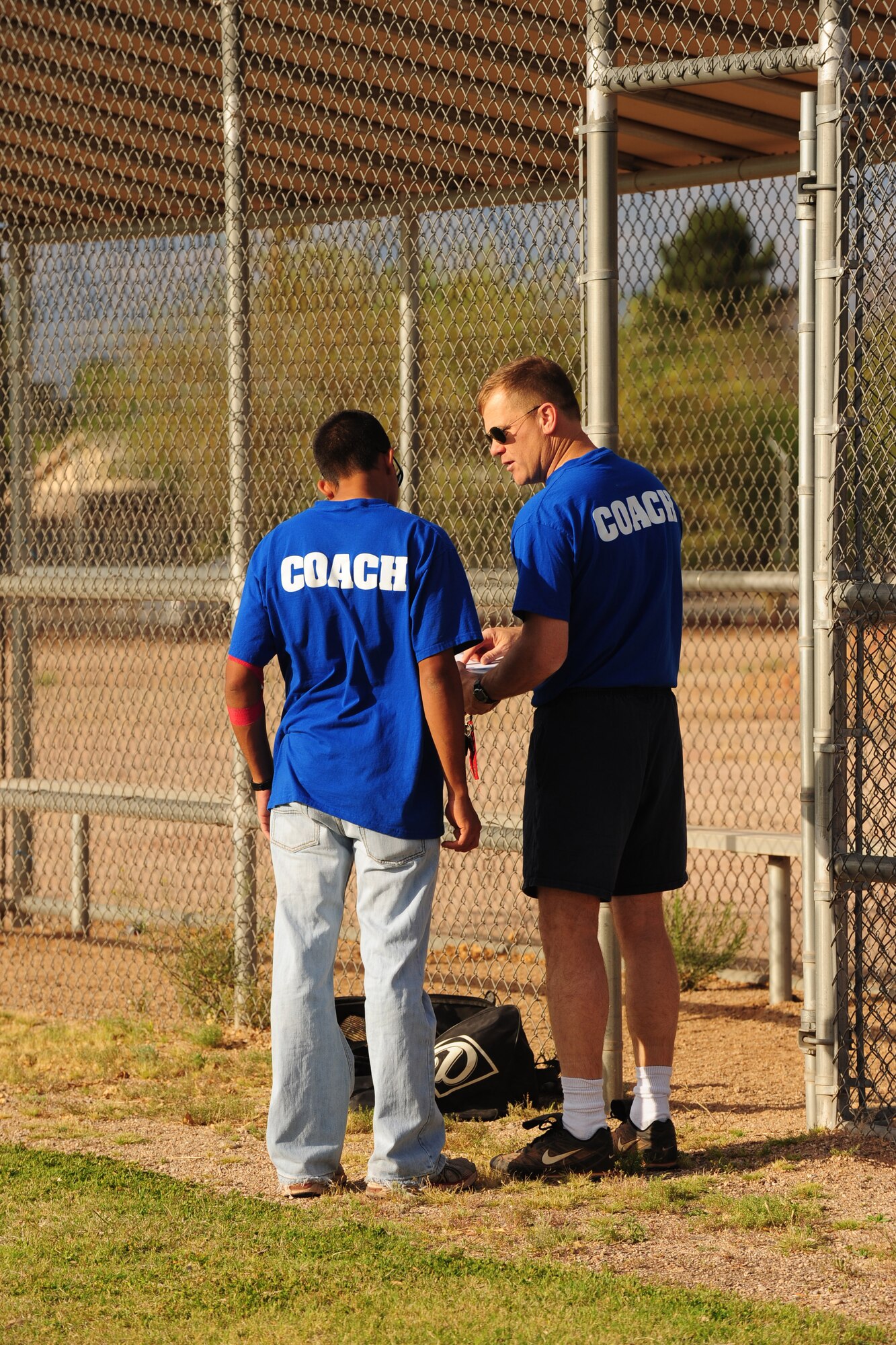 DAVIS-MONTHAN AIR FORCE BASE, Ariz. - Col. David Uselman, 355th Mission Support Group commander, and his assistant coach Airman 1st Class Miguel Camacho, from the 355th Civil Engineer Squadron, discuss the batting roster at the Corsair ball field here April 20. The colonel volunteers as coach for the D-M Dodgers tee ball team as part of a league for children between the ages of five and six. (U.S. Air Force photo/Airman 1st Class Jerilyn Quintanilla)