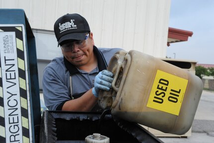 Harmin Aguilera, Hazmat Technician at the base Hazmat Facility, and contractor with Native Energies and Technologies, Pours used motor oil into a collection tank at Randolph Air Force Base, April 19, 2011.(U.S. Air Force photo/Airman Alexis Siekert)