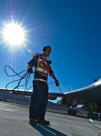 NELLIS AIR FORCE BASE, Nev. -- Staff Sgt. William Hatton, a crew chief from the 28th Aircraft Maintenance Squadron, Ellsworth Air Force Base, S.D., wraps up a cord before marshaling a B-1 Lancer during Green Flag West 11-6 April 26.  Green Flag West replicates irregular warfare conditions currently found in Southwest Asia. Aircrews, work closely with Air Force joint terminal attack controllers. Pilots train for a missions such as close air support, and aerial reconnaissance. (U.S Air Force Photo by Airman 1st Class Daniel Hughes)