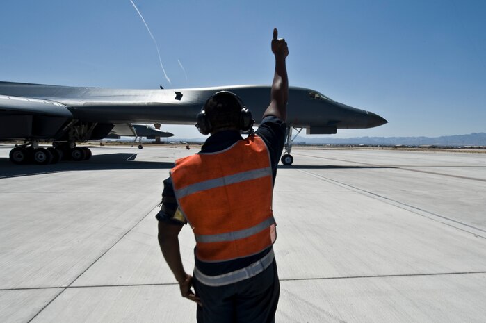 NELLIS AIR FORCE BASE, Nev. -- Airman 1st Class Samuel Carr, a crew chief from the 28th Aircraft Maintenance Squadron, Ellsworth Air Force Base, S.D. marshals a B-1 Lancer during Green Flag West 11-6, April 25.  Green Flag West replicates irregular warfare conditions currently found in Southwest Asia. Aircrews, work closely with Air Force joint terminal attack controllers. Pilots train for a missions such as close air support, and aerial reconnaissance. (U.S Air Force Photo by Airman 1st Class Daniel Hughes)
