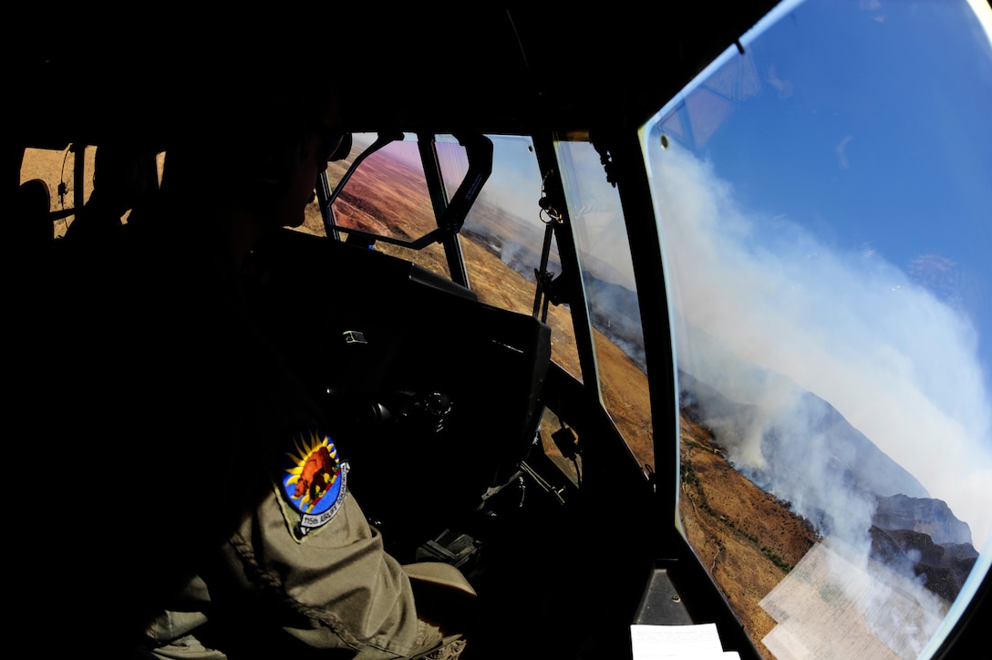 U.S. Air Force Maj. Kevin DeHart, 115th Airlift Squadron, California Air National Guard, prepares to drop a line of fire retardant while aboard a C-130J Hercules over West Texas, April 27, 2011.  The C-130 is equipped with the Modular Airborne Firefighting System(MAFFS) which is capable of dispensing 3,000 gallons of water or fire retardant in under 5 seconds.  The wildfires have spread across various parts of Texas and have burned more than 1,000 square miles of land.  (U.S. Air Force Photo/Staff Sgt. Eric Harris)