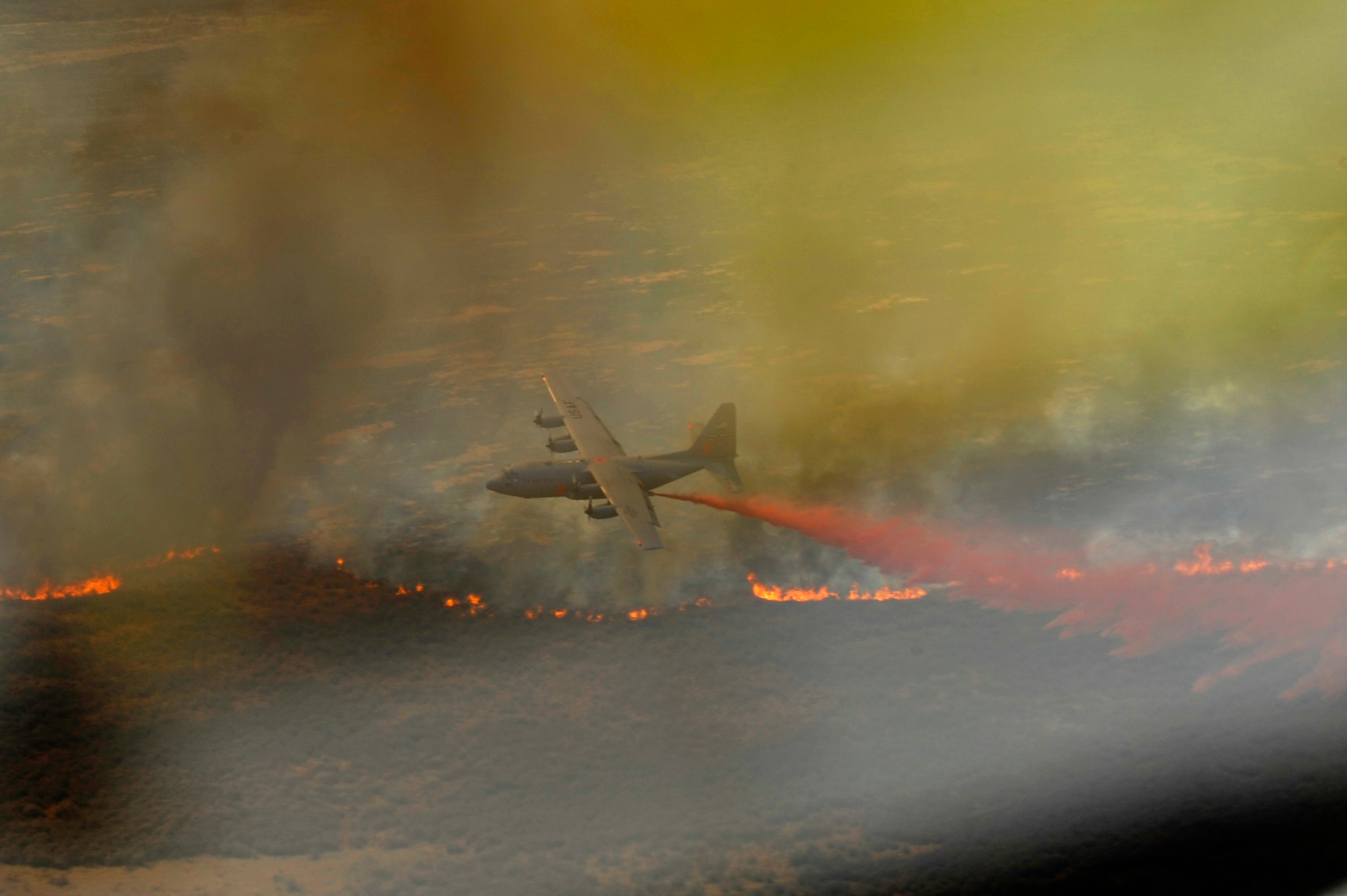 A C-130H Hercules from the 302nd Airlift Wing, Colorado Springs Air Force Reserve, equipped with the Modular Airborne Firefighting System (MAFFS) drops a line of fire retardant in West Texas, April 27, 2011.  MAFFS is capable of dispensing 3,000 gallons of water or fire retardant in under 5 seconds.  The wildfires have spread across various parts of Texas and have burned more than 1,000 square miles of land.  (U.S. Air Force Photo/Staff Sgt. Eric Harris)
