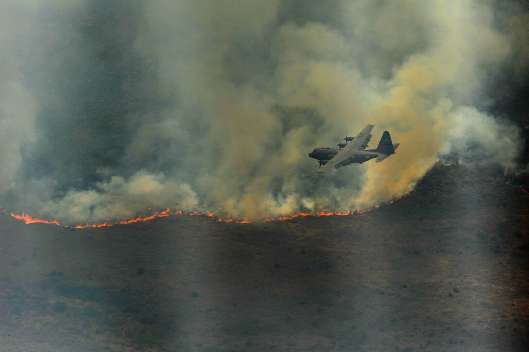 A C-130H Hercules from the 302nd Airlift Wing, Colorado Springs Air Force Reserve, equipped with the Modular Airborne Firefighting System (MAFFS) prepares to drop a line of fire retardant in West Texas, April 27, 2011.  MAFFS is capable of dispensing 3,000 gallons of water or fire retardant in under 5 seconds.  The wildfires have spread across various parts of Texas and have burned more than 1,000 square miles of land.  (U.S. Air Force Photo/Staff Sgt. Eric Harris)