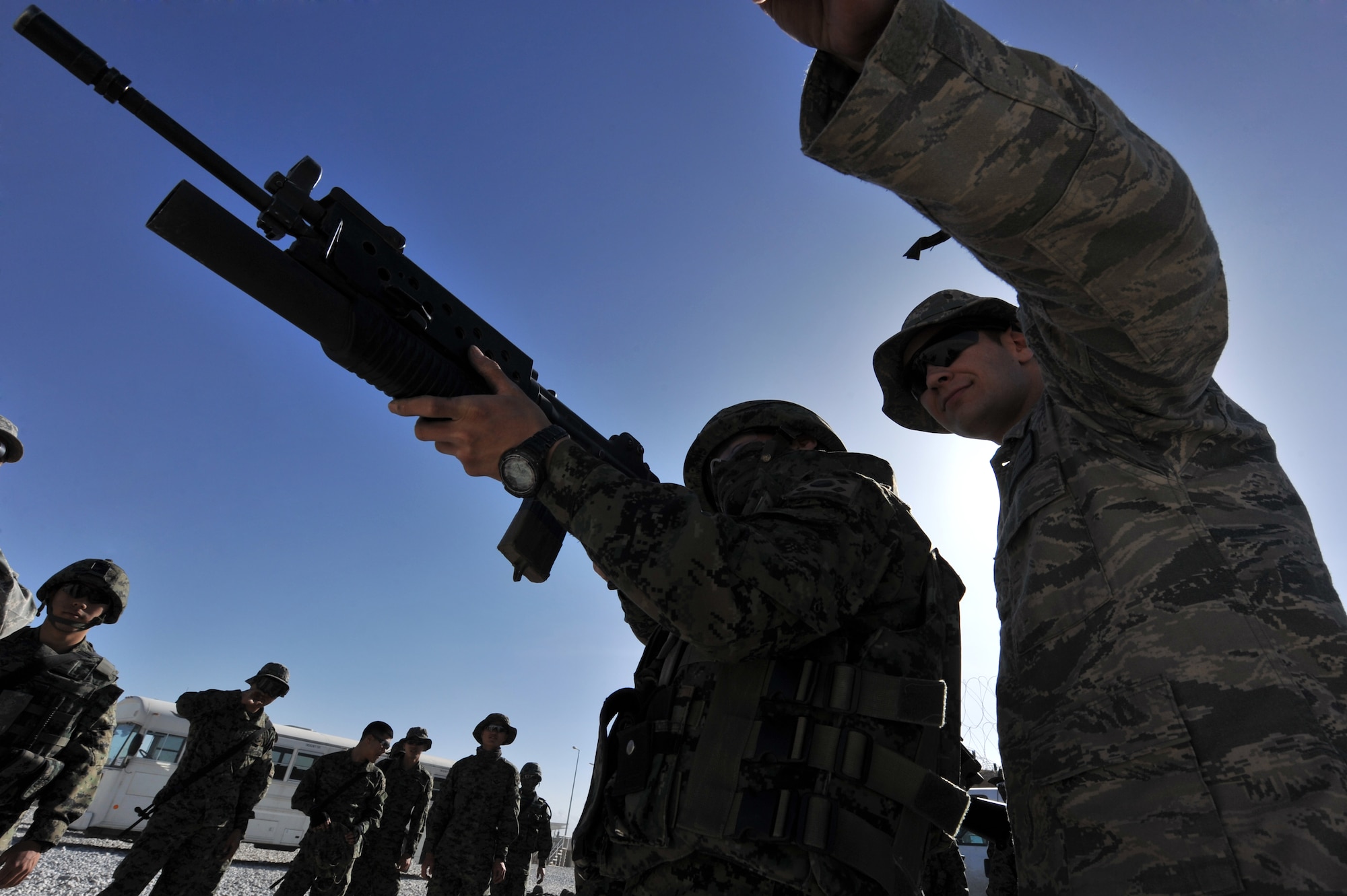Senior Airman Gary Farmer, 455th Expeditionary Security Forces Squadron, watches Staff Sgt. Jon Myung Jae, Republic of Korean army security forces, fires a non-lethal 40mm sponge round during a M203 grenade launcher training at Bagram Airfield, Afghanistan, April 22, 2011. Members from the ROK army security forces have to qualify on a M203 grenade launcher before joining Bagram’s base defense. (U.S. Air Force photo by Senior Airman Sheila Devera)