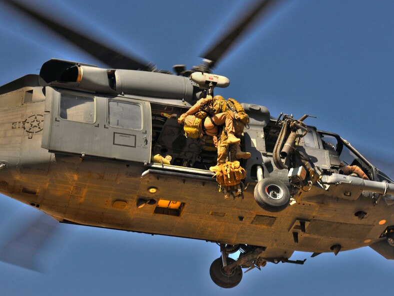 Airmen deployed from the 33rd Rescue Squadron hoist military personnel onto an HH-60G Pave Hawk during a training mission at Bagram Airfield, Afghanistan, Sept. 24, 2010. (U.S. Air Force photo illustration/Staff Sgt. Christopher Boitz and Senior Airman Shaunlee Hostutler) 