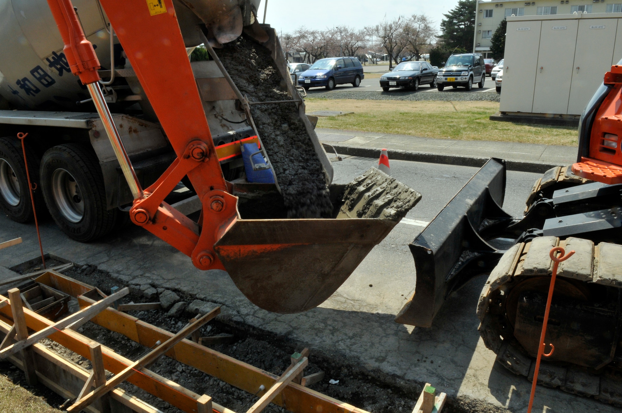 MISAWA AIR BASE, Japan – A cement mixer pours its contents into the bucket of a track hoe for distribution April 26. This Air Force project is destined to repair the pavements on Fleming Street. The estimated completion date is November. (U.S. Air Force photo/Tech. Sgt. Phillip Butterfield)