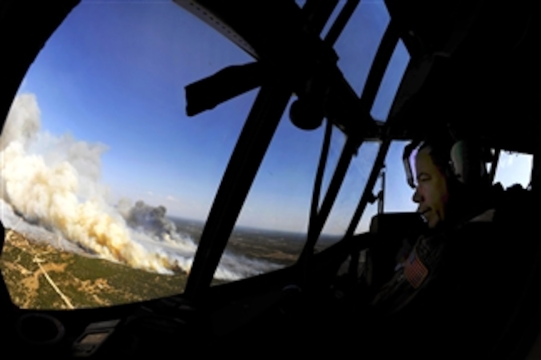 U.S. Air Force Lt. Col. Greg Ervin surveys the Oasis wildfire as they prepare to dispense fire retardant to assist firefighting efforts in West Texas on April 26, 2011.  Ervin, a C-130J Hercules pilot assigned to the 115th Airlift Squadron, California Air National Guard, is trained to fly with the Modular Airborne Firefighting System, which aids in the firefighting efforts.  