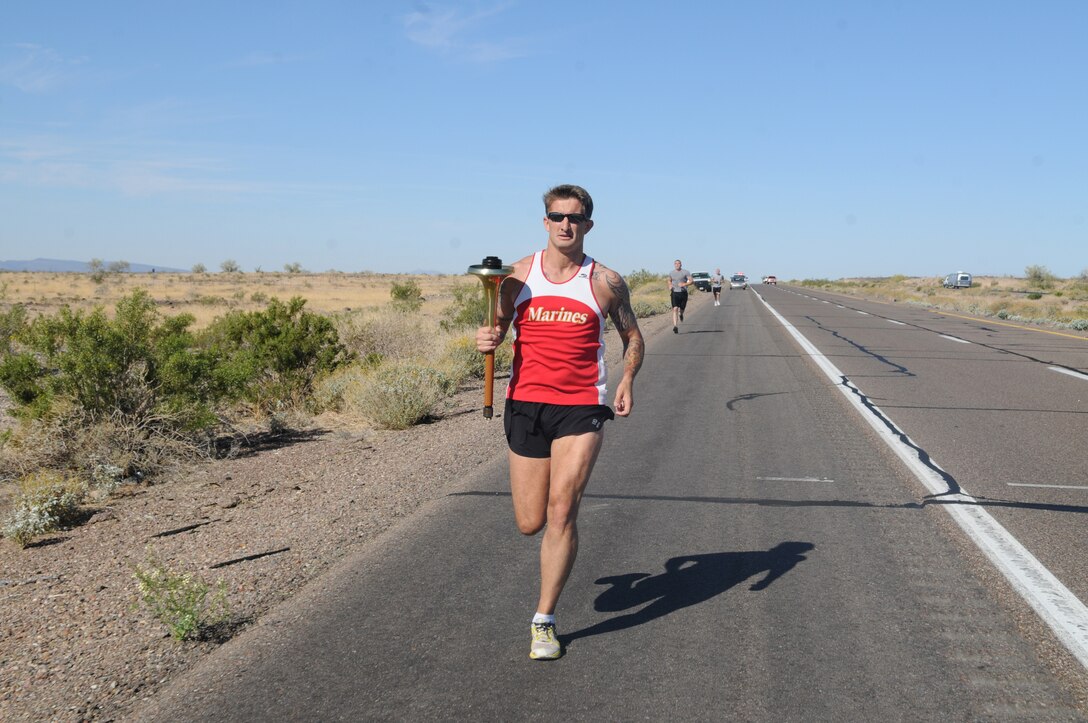 Gunnery Sgt. Scott Hubbard, criminal investigations division chief investigator, runs with a torch as part of the Law Enforcement Torch Run for the Special Olympics along a barren, open desert section of Interstate 8, April 28, 2011. Marines from the provost marshal’s office took part in the annual event, running 15 miles to raise money for the Special Olympics.