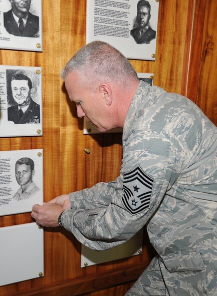 Chief Master Sgt Brooke McLean, Pacific Air Forces command chief, fastens a plaque dedicated to Chief Master Sgt. Richard Etchberger following a ceremony honoring Chief Etchberger April 29, 2011, at the Courtyard of Heroes, Joint Base Pearl Harbor-Hickam, Hawaii.  Chief Etchberger was posthumously awarded the Medal of Honor for his heroism during a then-classified mission in Laos, where he died March 11, 1968, under enemy fire. (U.S. Air Force photo/Tech. Sgt. Matthew McGovern)