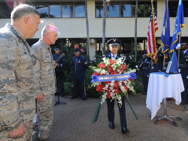 Gen. Gary North, Pacific Air Forces commander, (left) and Chief Master Sgt Brooke McLean, PACAF command chief, watch an honor guard member present a wreath dedicated to Chief Master Sgt. Richard Etchberger April 29, 2011, at Joint Base Pearl Harbor-Hickam. (U.S. Air Force photo/Tech. Sgt. Matthew McGovern)