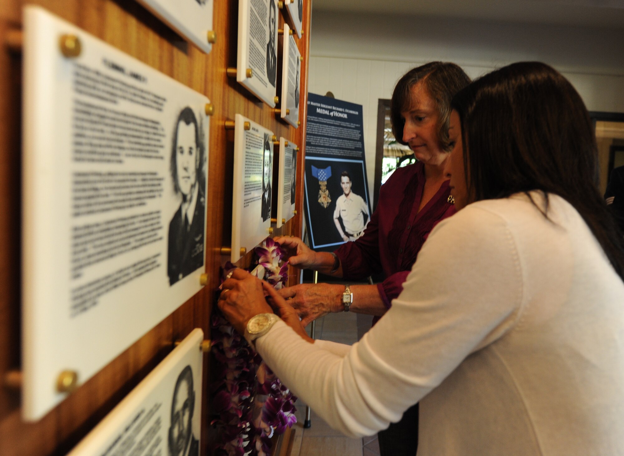 Mrs. Shelley North (left), spouse of Gen. Gary North, Pacific Air Forces commander, and Mrs. Maria McLean, spouse of Chief Master Sgt Brooke McLean, PACAF command chief, hang Leis on the plaque dedicated to Chief Master Sgt. Richard Etchberger April 29, 2011 at the Courtyard of Heroes, Joint Base Pearl Harbor-Hickam, Hawaii.  Chief Etchberger was posthumously awarded the Medal of Honor for his heroism during a then-classified mission in Laos, where he died March 11, 1968, under enemy fire. (U.S. Air Force Photo/Tech. Sgt. Matthew McGovern)