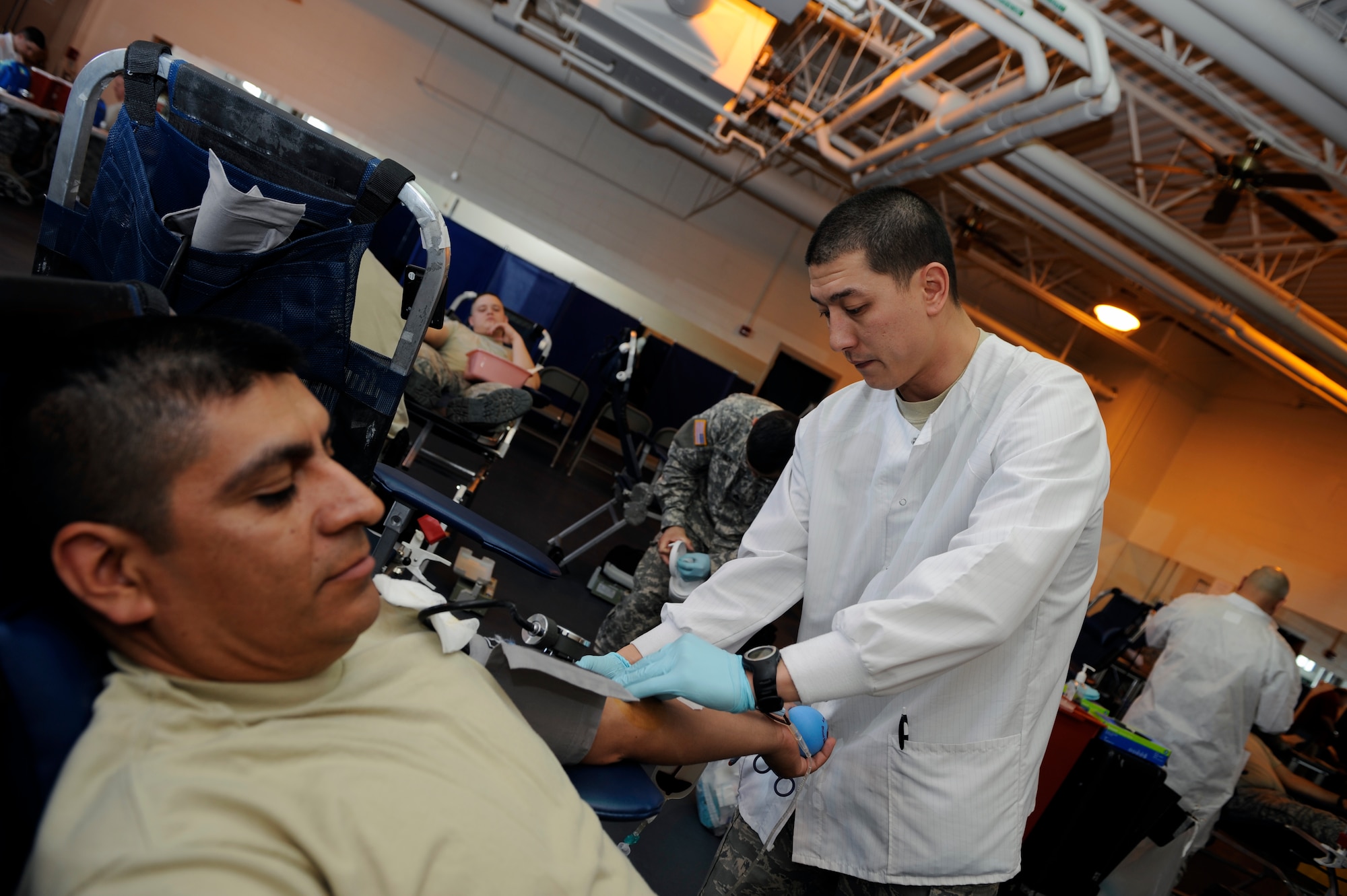 MOUNTAIN HOME AIR FORCE BASE, Idaho -- Senior Airman Logan Beltz, mobile laboratory technician stationed at Joint Base Lewis-McChord, Wash., preps Tech Sgt. Victor Salvador, 366th Force Support Squadron, before the sergeant donates a pint of blood during the blood drive hosted April 25-26. Sergeant Salvador was one of the 158 volunteers who donated, resulting in 118 units of blood product.  (U.S Air Force photo by Senior Airman Angelina Drake)