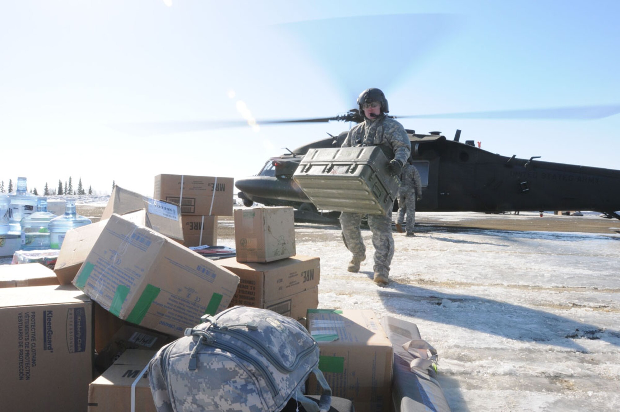 NULATO, Alaska -- A crew chief from A Company, 1st Battalion, 207th Aviation Regiment, unloads a UH-60 Black Hawk during a supply drop in the remote village of Nulato, Alaska. The supplies will replenish the medical personnel station in the village during Arctic Care 2011. (Photo by Sgt. Craig Anderson/80th Medical Deployment Support Command PA)