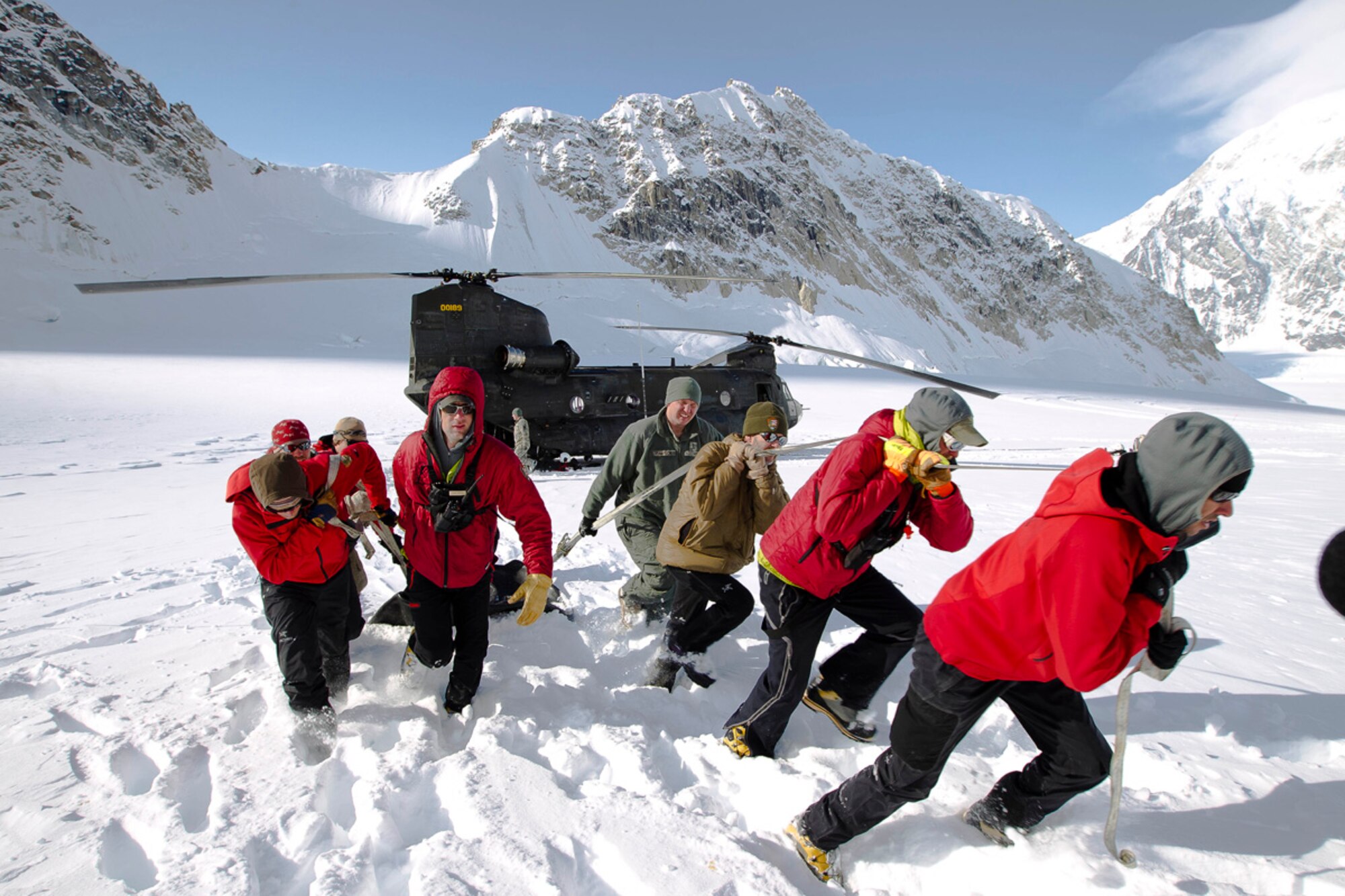 MOUNT MCKINLEY, Alaska -- Chief Warrant Officer 3 Mark Simon of 1st Battalion, 52nd Aviation Regiment, 16th Combat Aviation Brigade, helps National Park Service mountaineering rangers unload survival equipment from a CH-47 Chinook helicopter on the Base Camp on the Lower Kahiltna Glacier in Denali National Park. Soldiers from the 1-52nd ???Flying Dragons??? provided cargo assistance to the rangers??? effort to establish this season???s base camp for mountain climbers preparing to ascend Mount McKinley or other peaks nearby. (Photo by Army Staff Sgt. Brehl Garza/USARAK TDT)