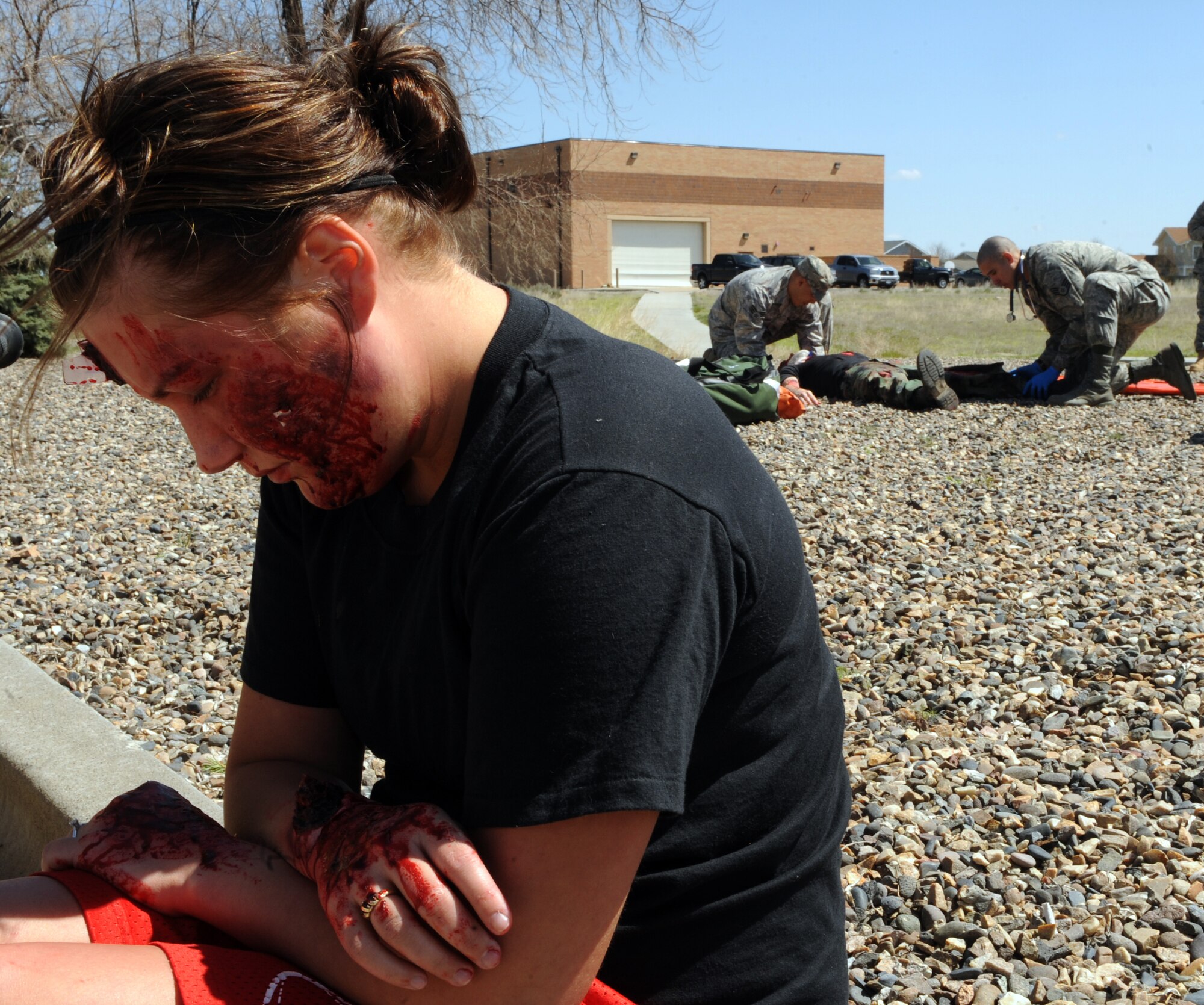 MOUNTAIN HOME AIR FORCE BASE, Idaho – Senior Airman Erin Hanner, 366th Medical Group, poses as a vehicle accident victim while medics perform triage on another “victim” outside of the base hospital during Medical Group day April 22. Airmen from the 366th MDG volunteered their time to demonstrate the hospital’s capabilities to the honorary commanders program, which provides a glimpse of military life to members of neighboring communities -- many of whom have no connection to the Air Force. (U.S. Air Force photo by Senior Airman Debbie Lockhart)