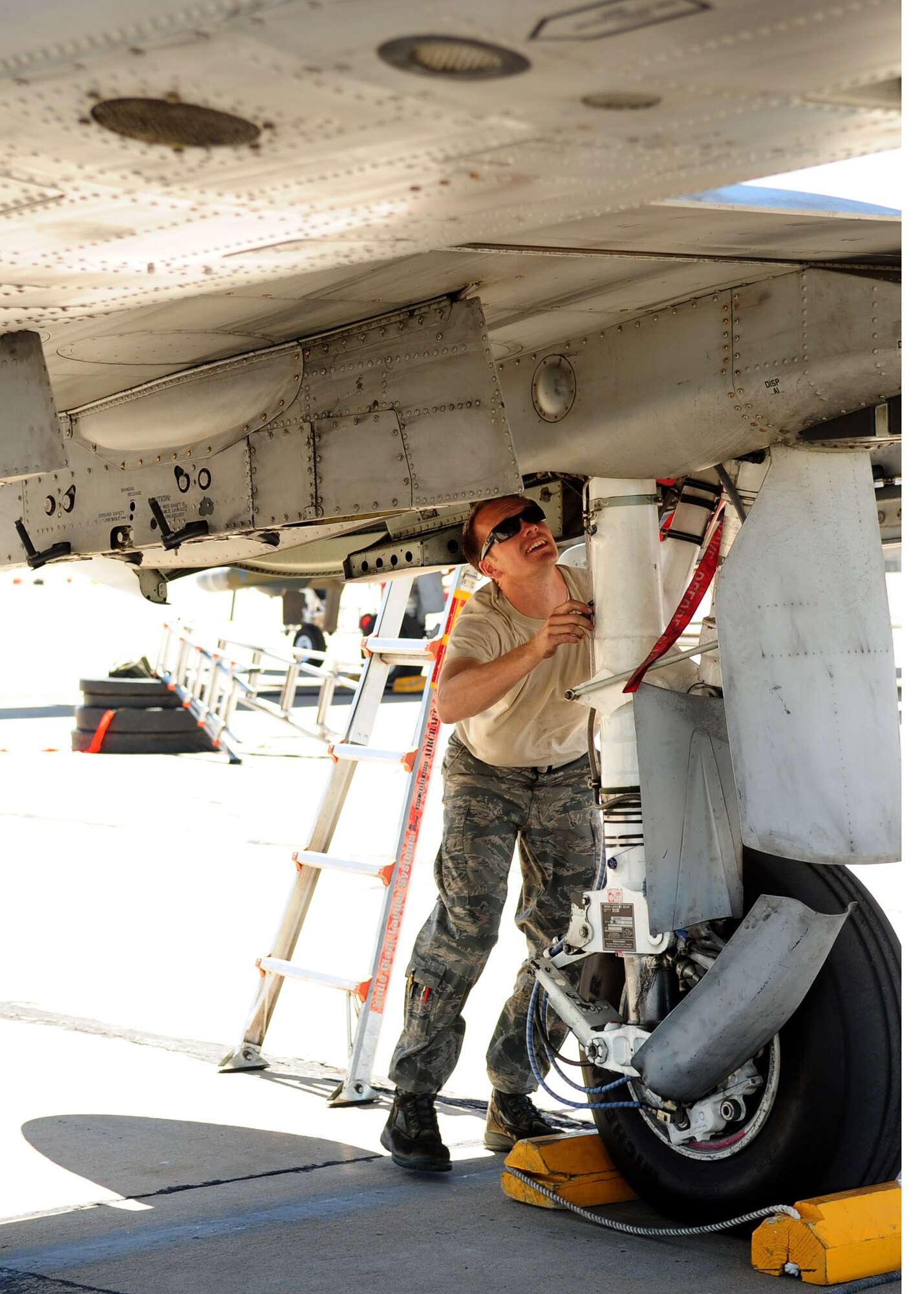 TUCSON, Ariz. - Staff Sgt. Matthew Bailey, from the 355th Aircraft Maintenance Squadron, inspects the landing gear of an A-10 aircraft on the flight line at Tucson International Airport here April 27. D-M closed its runway for routine maintenance in March. Routine maintenance is required to preserve the integrity of the runway and was last performed in 2002. Base flying missions have been operating out of TIA and other locations. (U.S. Air Force photo/Airman 1st Class Jerilyn Quintanilla)