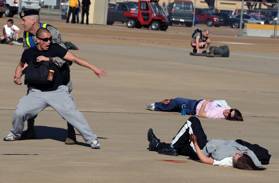 A volunteer during a major accident acts as a distraught spectator while being pulled away from a loved one by a member of the 2nd Security Forces Squadron on Barksdale Air Force Base, La., April 29. Security Forces members must clear accident scenes to ensure there are no additional injuries. Safety is a major concern for team Barksdale. (U.S. Air Force photo/Airman 1st Class Micaiah Anthony)(RELEASED)