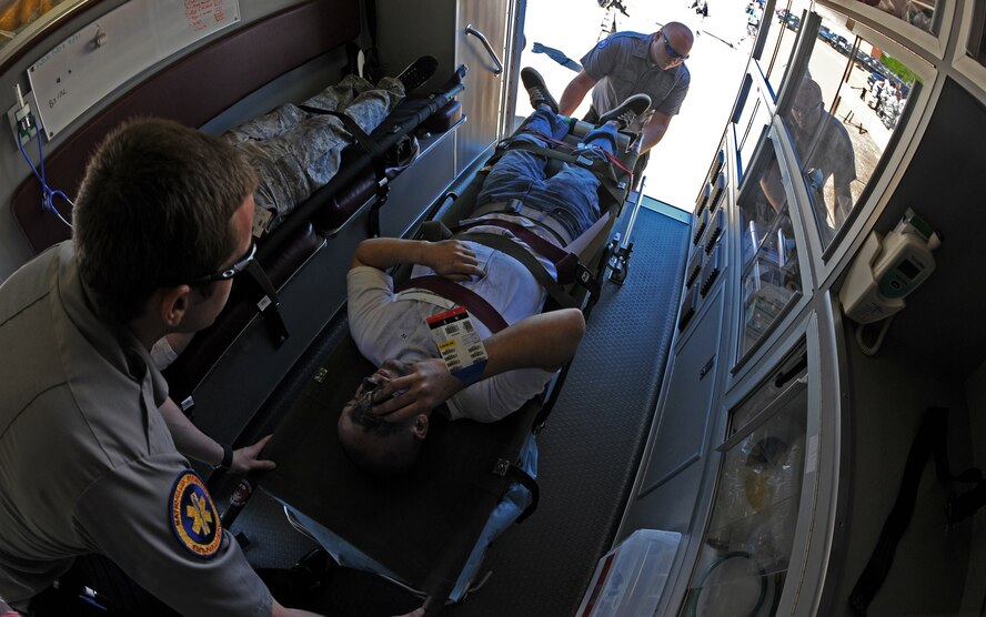 An Airman acting as an injured spectator is loaded into an ambulance by local paramedics during the Major Accident Response Exercise on Barksdale Air Force Base, La., April 29. Once loaded, the paramedics scan the Emergency Tracking System Tag which notifies the hospital of the patient's injuries and symptoms via e-mail. The EMTRAC System is used by the local Shreveport/Bossier emergency responders and medical facilities for mass casualties. (U.S. Air Force photo/Airman 1st Class Micaiah Anthony)(RELEASED)