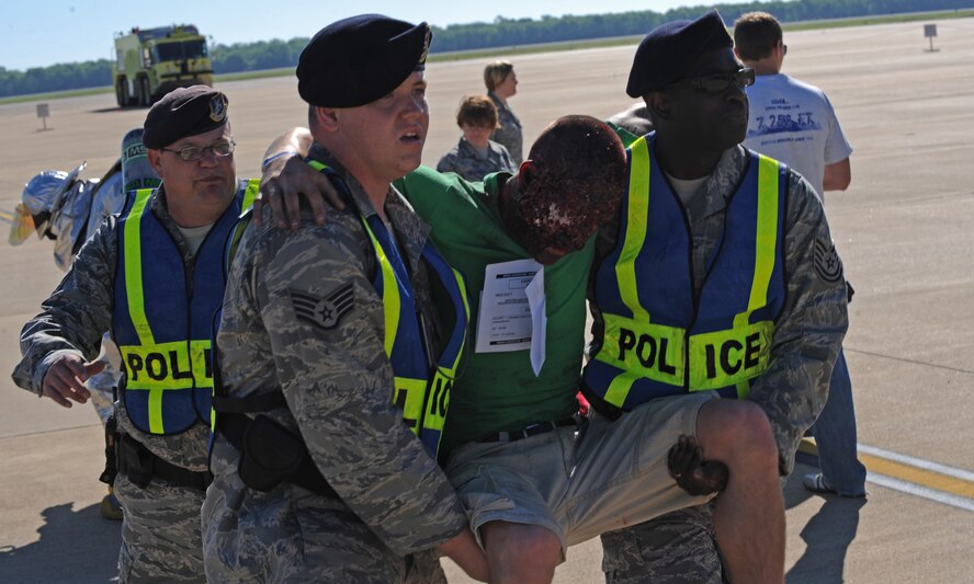 Members of the 2nd Security Forces Squadron carry an Airman acting as an injured spectator to safety during the Major Accident Response Exercise on Barksdale Air Force Base, La., April 29. Burns, fractures, head injuries and open wounds were some of the injuries simulated in the exercise. The MARE helps emergency personnel on and off base prepare for major accidents. (U.S. Air Force photo/Airman 1st Class Micaiah Anthony)(RELEASED)