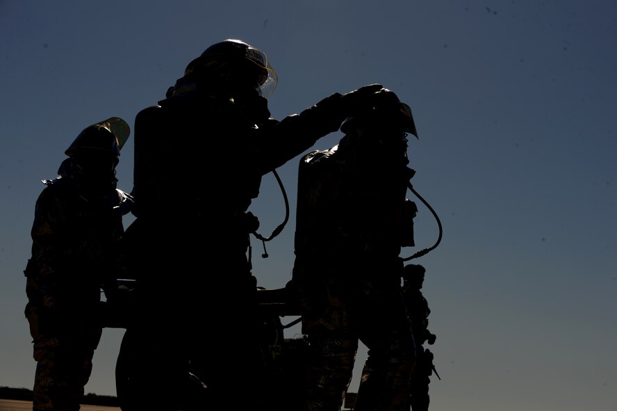 Fire fighters from the 2nd Civil Engineer Squadron carry an Airman acting as an injured victim from a simulated crash site during the Major Accident Response Exercise on Barksdale Air Force Base, La., April 29. Burns, fractures, head injuries and open wounds were some of the injuries simulated in the exercise. The MARE helps emergency personnel on and off base prepare for major accidents. (U.S. Air Force photo/Airman 1st Class Micaiah Anthony)(RELEASED)