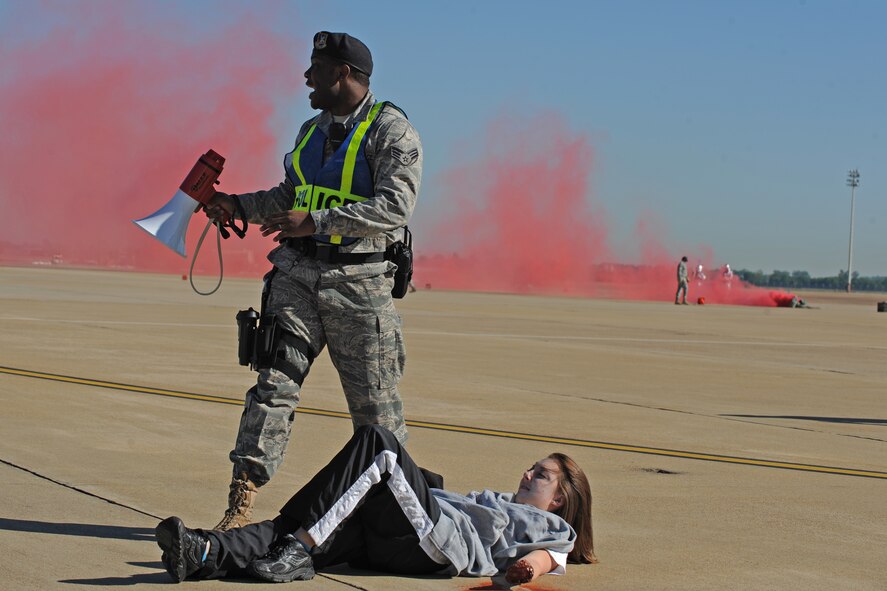 A member of the 2nd Security Forces Squadron calls for help to assist with a simulated casualty during a Major Accident Response Exercise on Barksdale Air Force Base, La., April 29. Burns, fractures, head injuries and open wounds were some of the injuries simulated during the exercise to help emergency personnel on and off base prepare for major accidents. (U.S. Air Force photo/Airman 1st Class Micaiah Anthony)(RELEASED)
