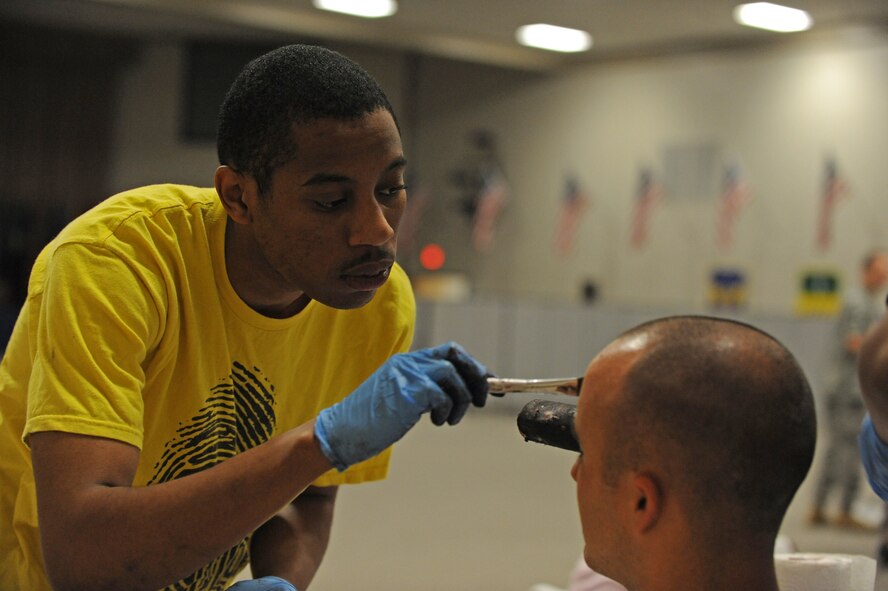 Airman 1st Class Christopher Scippio, 2nd Medical Group, applies make up and fake blood to Airman 1st Class Joshua Zermeno, 2nd Maintenance Squadron, in preparation for a Major Accident Response Exercise on Barksdale Air Force Base, La., April 29. Airmen who volunteered were assigned roles as injured bystanders, pilots and military personnel. Accident victims received a sheet listing their injuries, symptoms and emotional states to help them play their roles. (U.S. Air Force photo/Airman 1st Class Micaiah Anthony)(RELEASED)